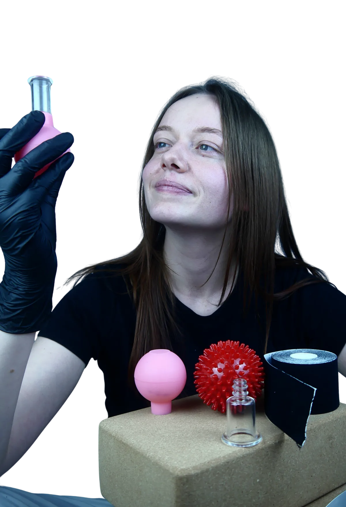 Maja holding a cupping cup, with massage tools on a cork block